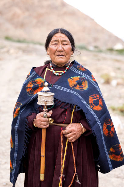 istock Old woman holding hand prayer wheel 826001246