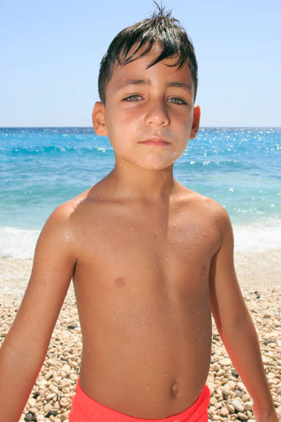 Boy with beautiful green eyes on the beach