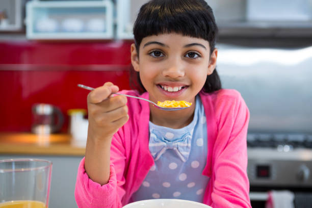 istock Girl holding breakfast cereal in spoon at home 826008604