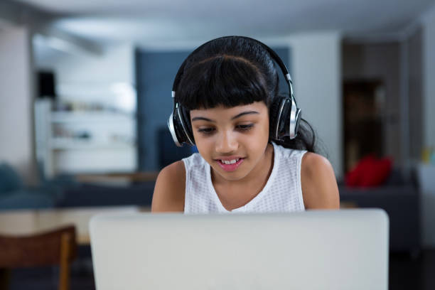 istock Girl using laptop while listening music from headphones 826011716