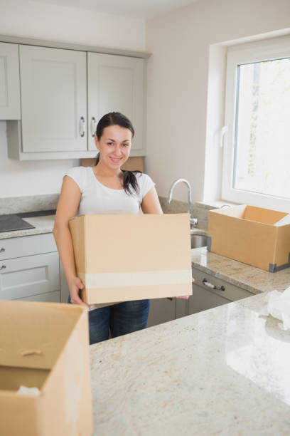 istock Smiling woman holding a moving box 826025786