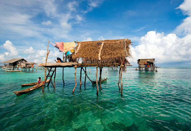 Bajau Laut Floating Village in Semporna Semporna, Malaysia - 19 April, 2015: A Bajau laut floating village of stilted houses off the coast of Borneo in The Celebes Sea in the vicinity of Sipidan and Tun Sakaran Marine Park. mabul island stock pictures, royalty-free photos & images