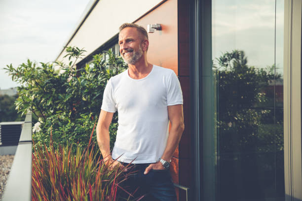 bel homme debout sur un balcon - mature men photos et images de collection