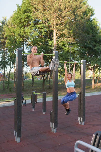 istock Caucasian  man and woman doing calisthenics exercises on horizontal bars 826036270