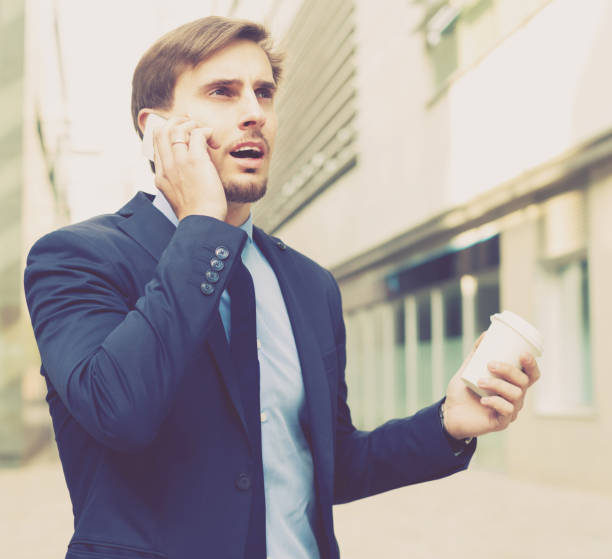 istock Smiling male worker talking on the phone with coffee 826036656