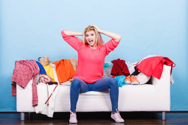 istock Woman does not know what to wear sitting on couch 826038032