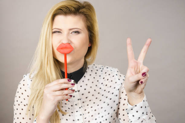 istock Happy woman holding fake lips on stick 826040874