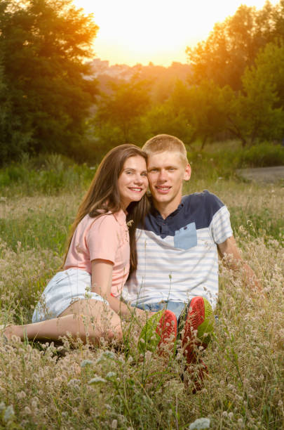 istock happy loving couple sitting on a field 826041310