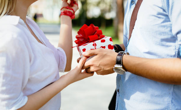 istock Man standing and holding white surprise gift box behind his back 826043788