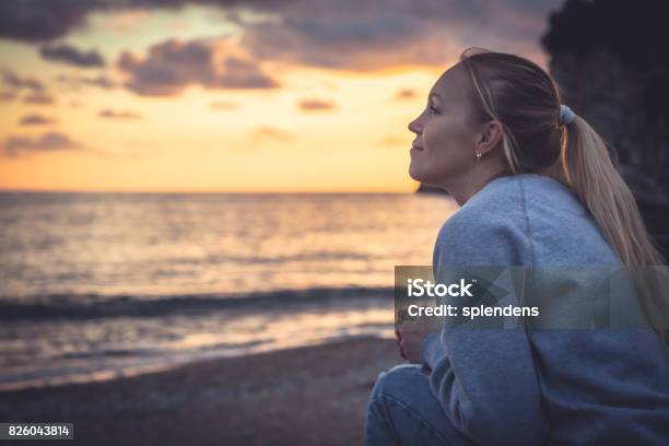 Pensive Lonely Smiling Woman Looking With Hope Into Horizon During Sunset At Beach Stock Photo - Download Image Now