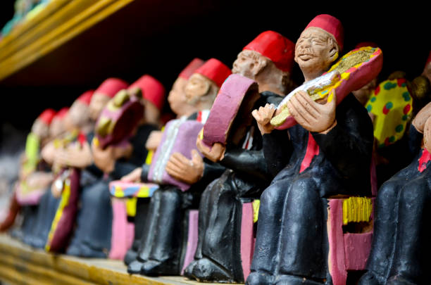 istock small statues of old men playing on music instruments, 826047380