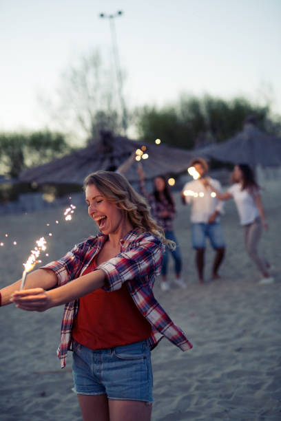 istock Group of happy friends having fun on beach at night 826055368