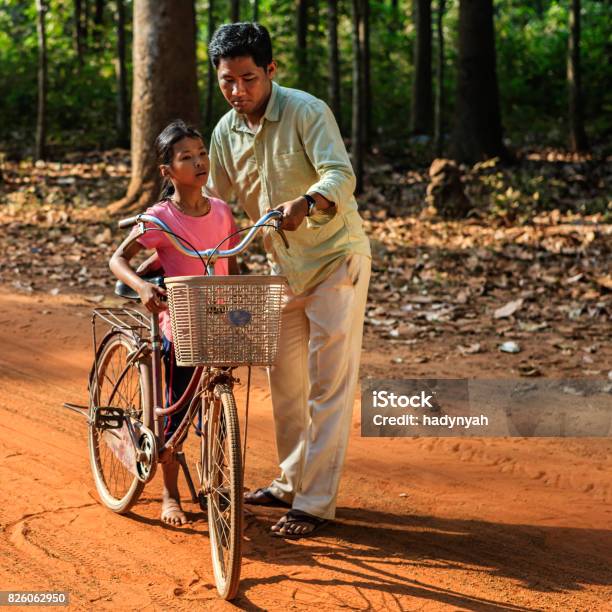 Young Father Teaching His Daughter How To Ride Bicycle Cambodia Stock Photo - Download Image Now
