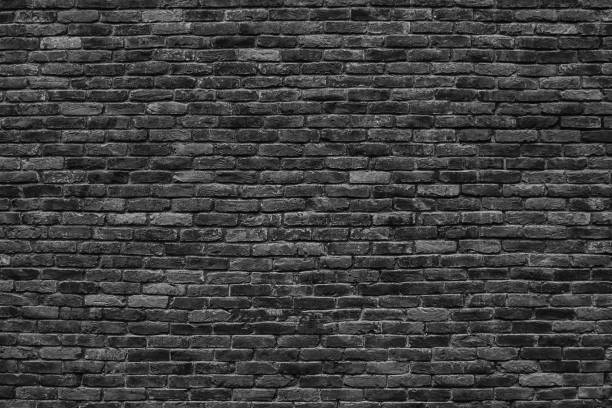 istock gloomy background, black brick wall of dark stone texture 826068410