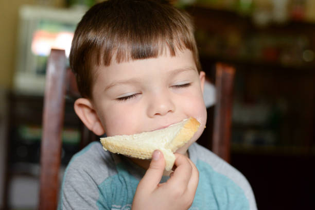 Children and gluten. Preschool boy with toasted bread, with sad emoji. Gluten intolerance by kids