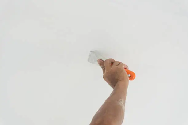 Closeup of palette-knife or scraper and cement filling for house renovation construction