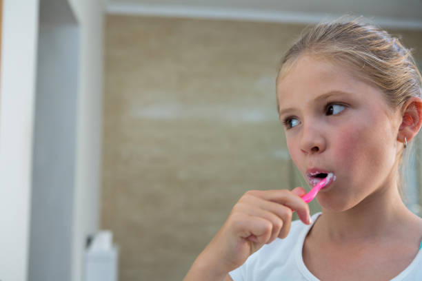 istock Close up of girl brushing teeth 826089038