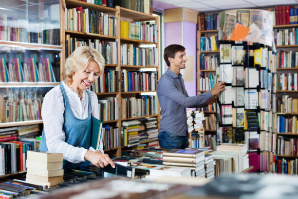 istock Mature smiling woman picking new book 826111600