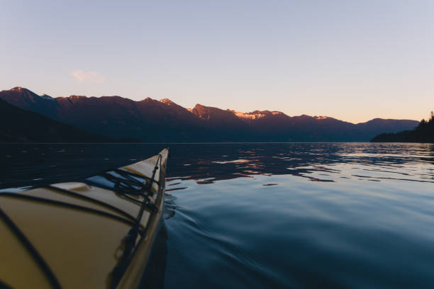 istock Kayaking alone on calm water with mountains in the background while sunset 826130604