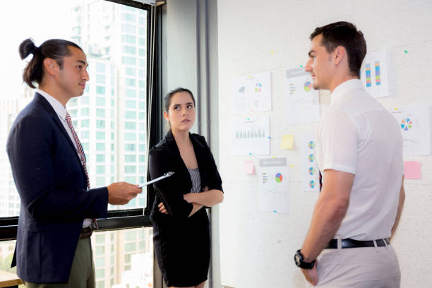 istock three business people in modern office looking report and analyzing with talking in meeting room. 826134420