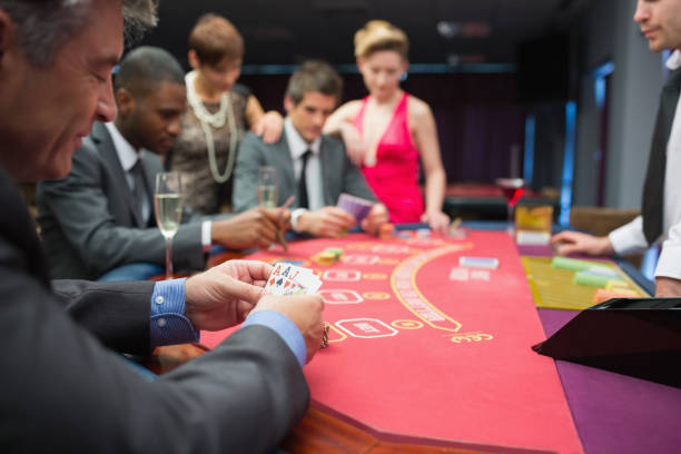 istock Man looking happily at his poker hand 826140488