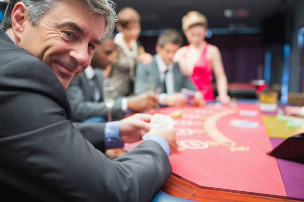 homme souriant à la table de poker - casino black and white gambling chip gambling photos et images de collection