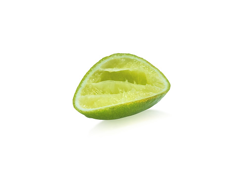 Green lime on isolated white background. A half piece of squeezed lemon for seasoning. ( Clipping path or cutout object for montage )