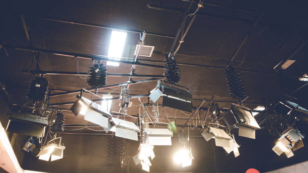 istock Spot light glowing on studio ceiling background. Illuminated lamp in entertainment stage on fade tone. 826162140