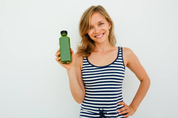 Cheeful beautiful young woman recommending shampoo