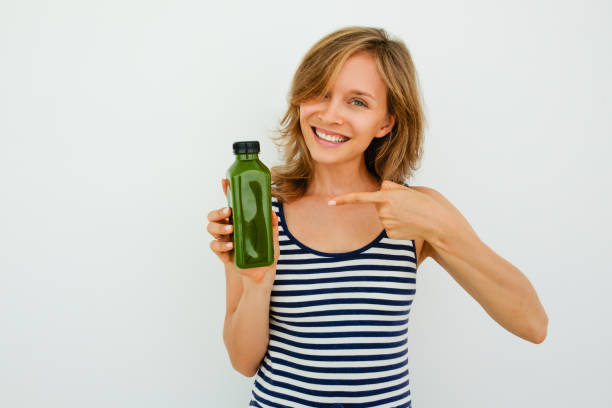 istock Cheerful young woman pointing at green bottle 826162842