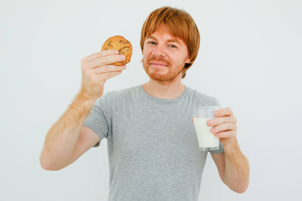 istock Content Red-haired Man Eating Cookie With Milk 826163890