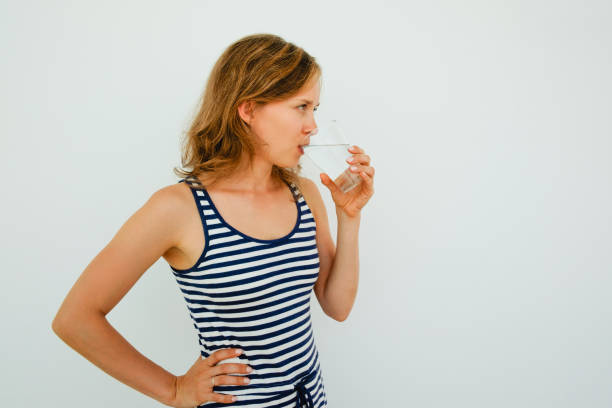 istock Attractive Young Woman Drinking Water From Glass 826163962