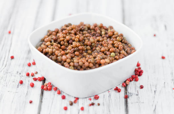 istock Portion of Pink Peppercorns (preserved) on wooden background, selective focus 826167658