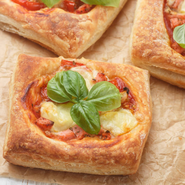 istock Open pies puff pastry with tomato, mozzarella, onion and Basil. Mini pizza. Selective focus 826168372