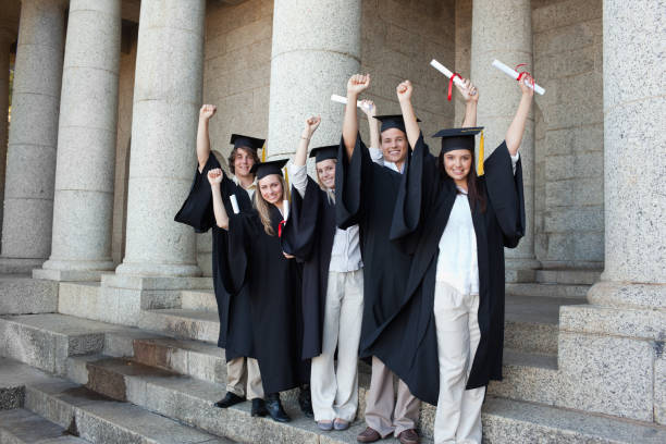 istock Five happy graduates posing the arms raised 826170468