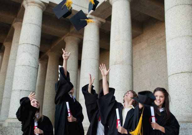 istock Happy graduates throwing their hats in the sky 826171142