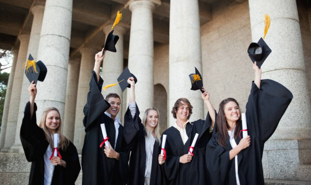 istock Smiling graduates holding up their hats 826171186