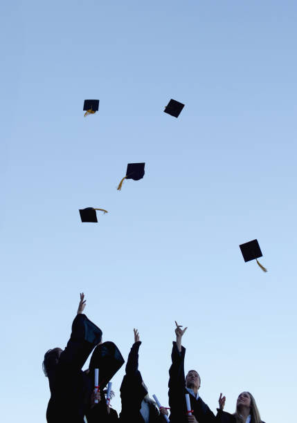 istock Five grad students throwing their hats high in the sky 826171224