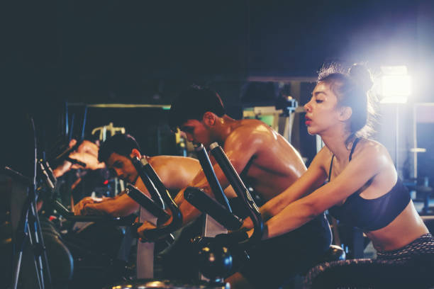 grupa osób na siłowni ćwiczenia nogi robi trening cardio - spinning gym cycle cycling zdjęcia i obrazy z banku zdjęć