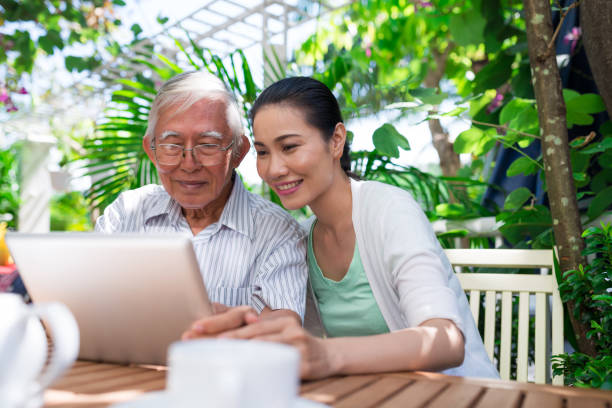 wesoły wietnamski ojciec i córka siedzą w kawiarni na świeżym powietrzu i oglądają coś na tablecie - father digital tablet asian ethnicity daughter zdjęcia i obrazy z banku zdjęć