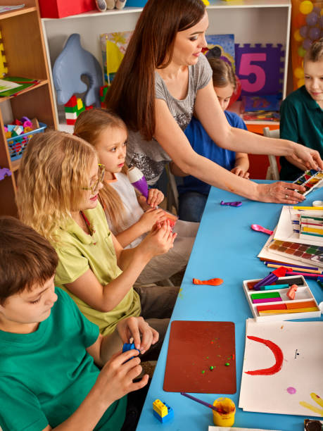 istock Plasticine modeling clay in children class. Teacher teaches in school. 826182298