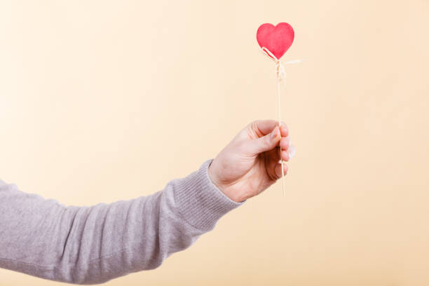 istock Male hand with little heart on stick. 826187836