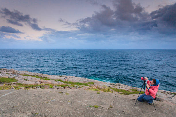 istock Tourist with camera on seashore, Norway 826187896