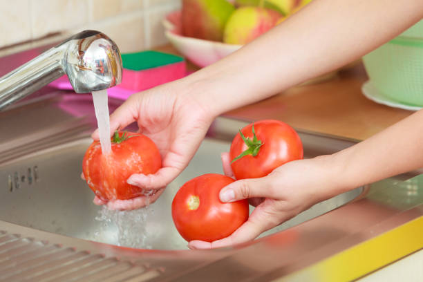 istock woman washing fresh vegetables in kitchen 826190856