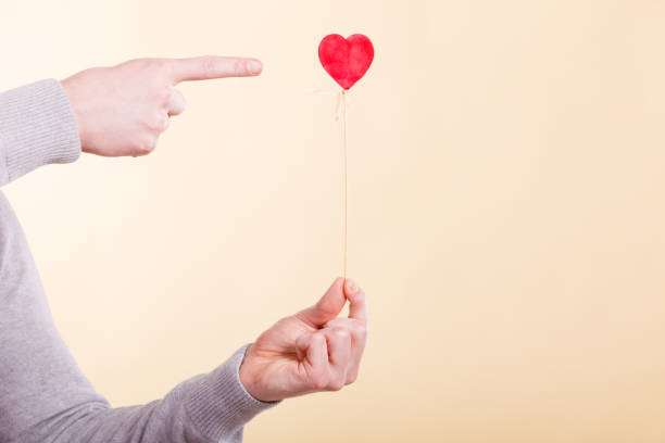 istock Male hand with little heart on stick. 826191530