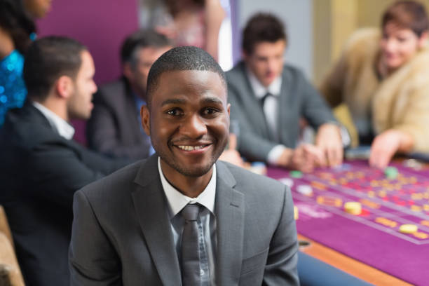 homme souriant, assis à la table de roulette - casino black and white gambling chip gambling photos et images de collection