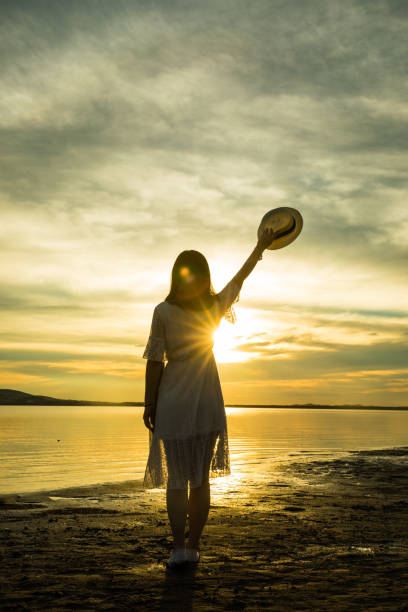 istock woman against sunset by lake 826195062