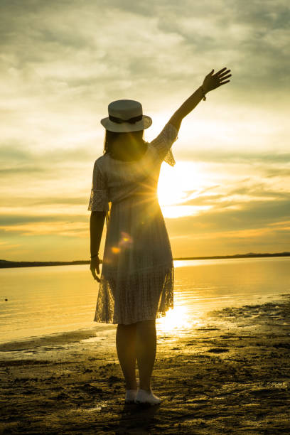 istock woman against sunset by lake 826195122