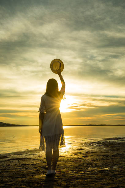 istock woman against sunset by lake 826195140