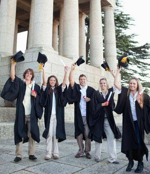 istock Five happy grad students raising their hats 826200576